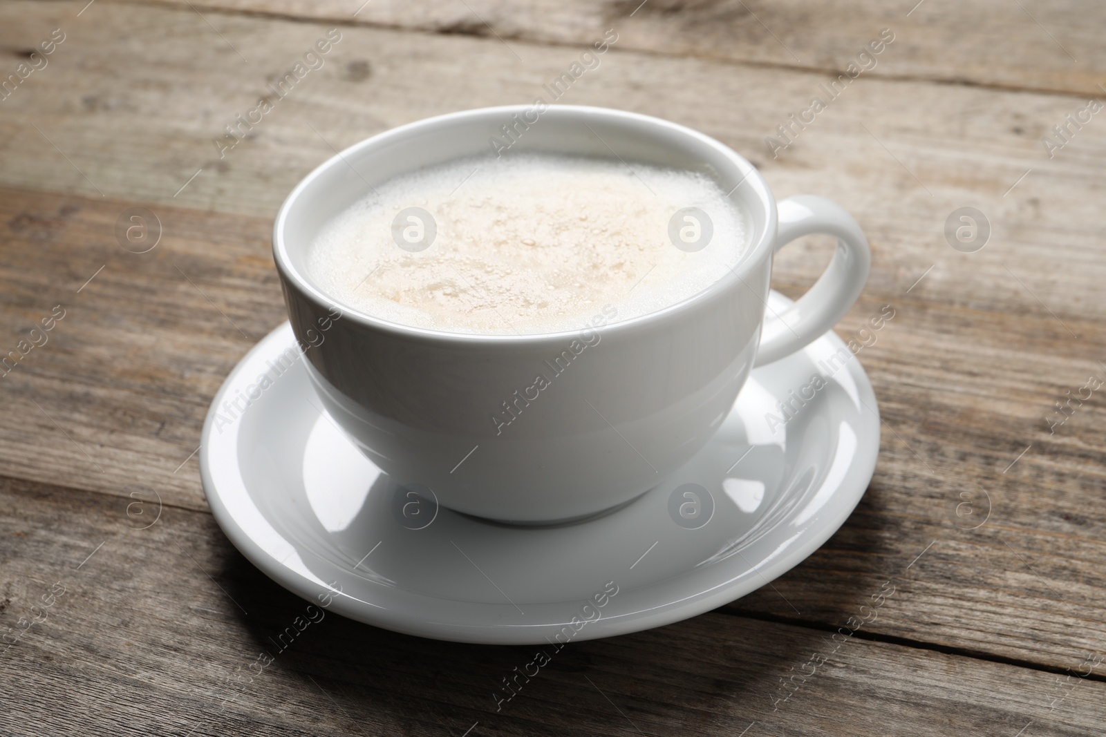 Photo of Aromatic coffee in cup on wooden table