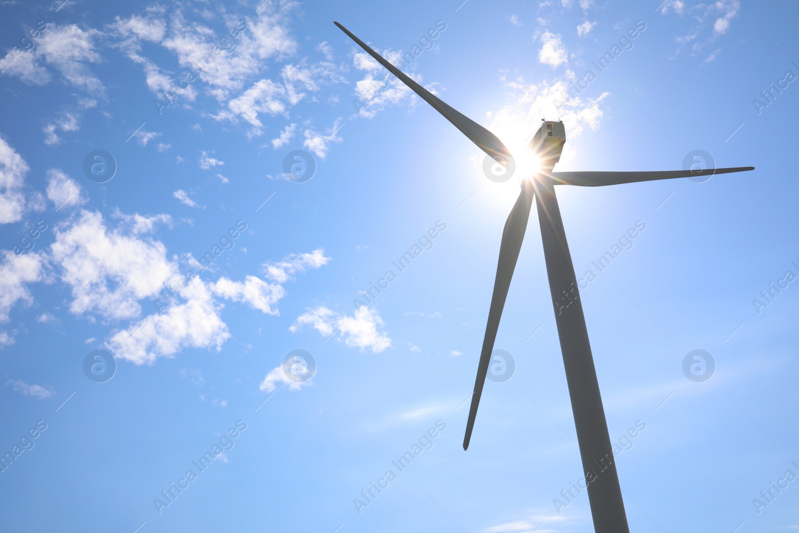 Photo of Wind turbine against beautiful blue sky, low angle view. Alternative energy source