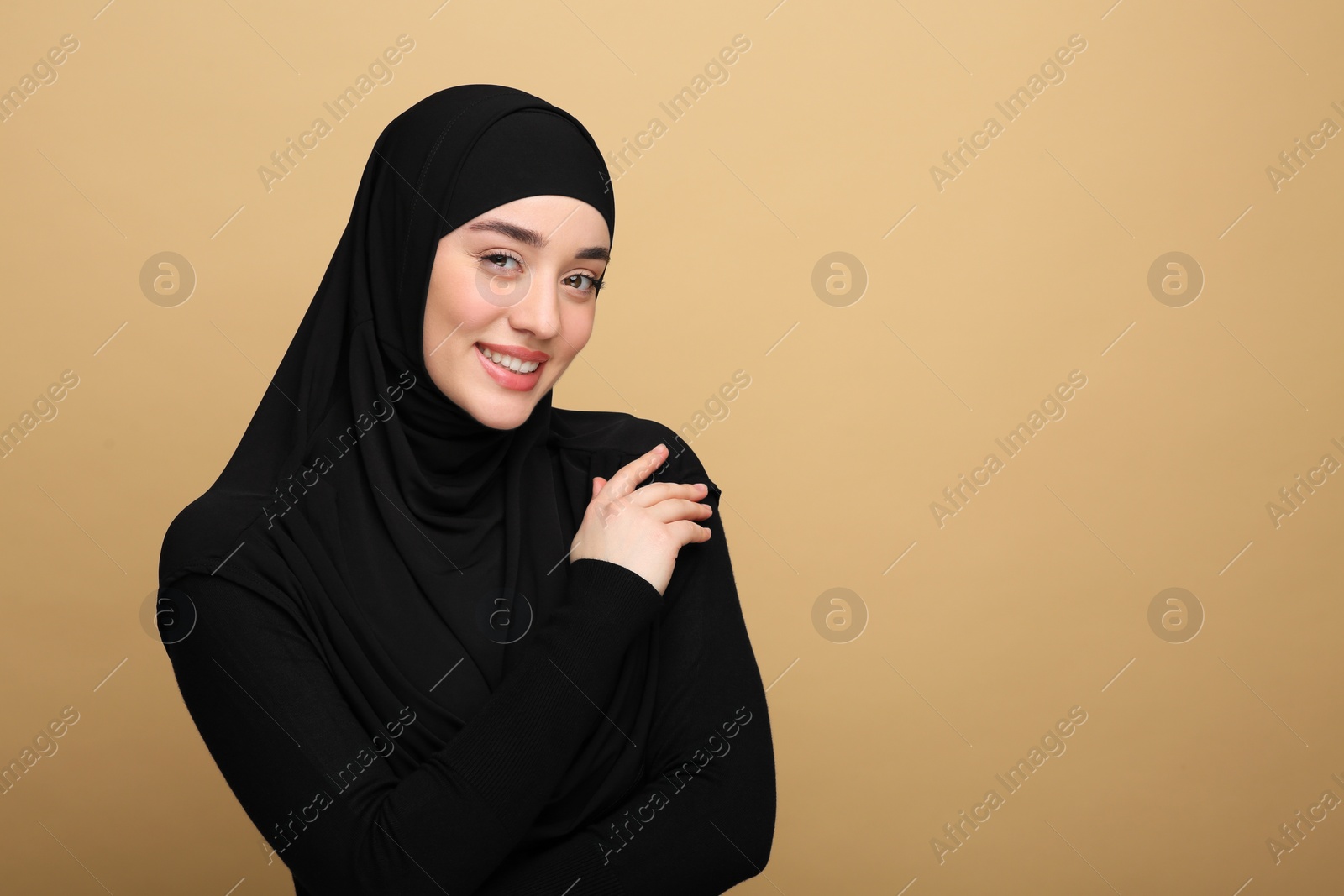 Photo of Portrait of Muslim woman in hijab on beige background. Space for text