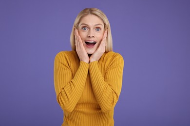 Photo of Portrait of surprised woman on violet background