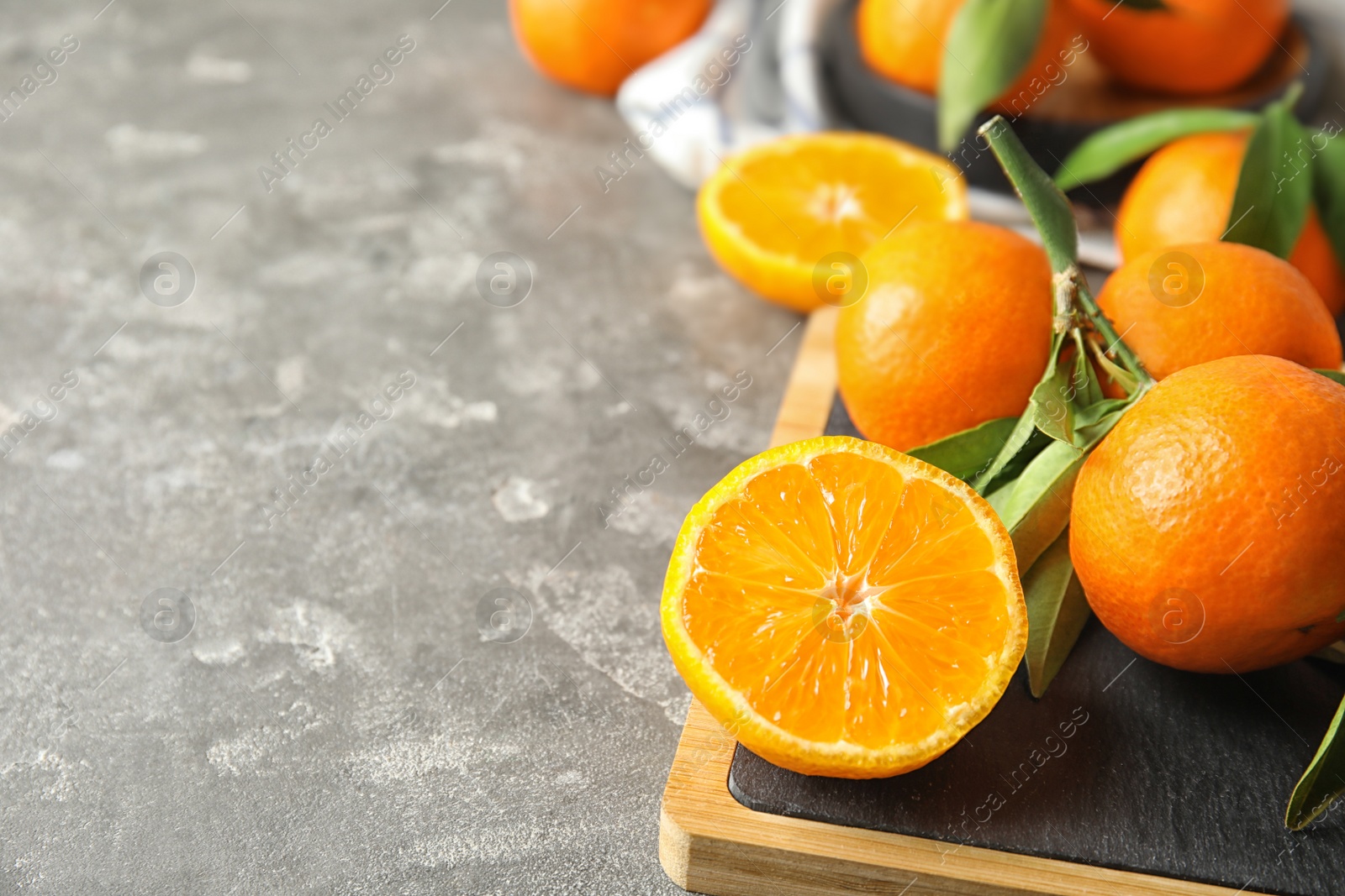 Photo of Board with ripe tangerines on table. Space for text