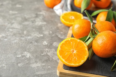 Photo of Board with ripe tangerines on table. Space for text