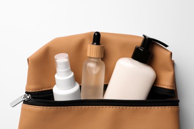 Photo of Preparation for spa. Compact bag with cosmetic products on white background, top view