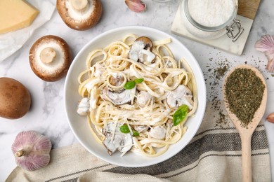 Delicious pasta with mushrooms served on white marble table, flat lay
