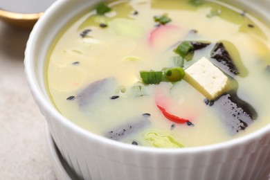 Bowl of delicious miso soup with tofu on table, closeup