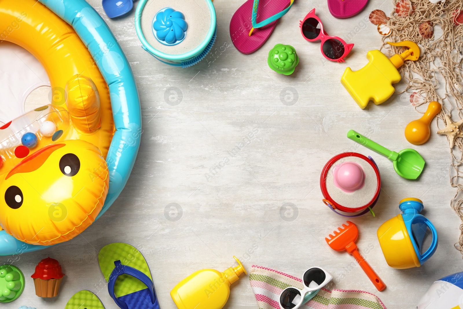 Photo of Flat lay composition with beach toys on light background. Space for text