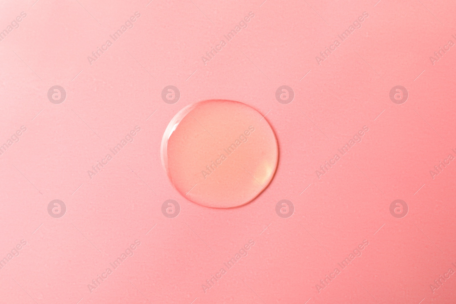 Photo of Drop of hydrophilic oil on pink background, top view