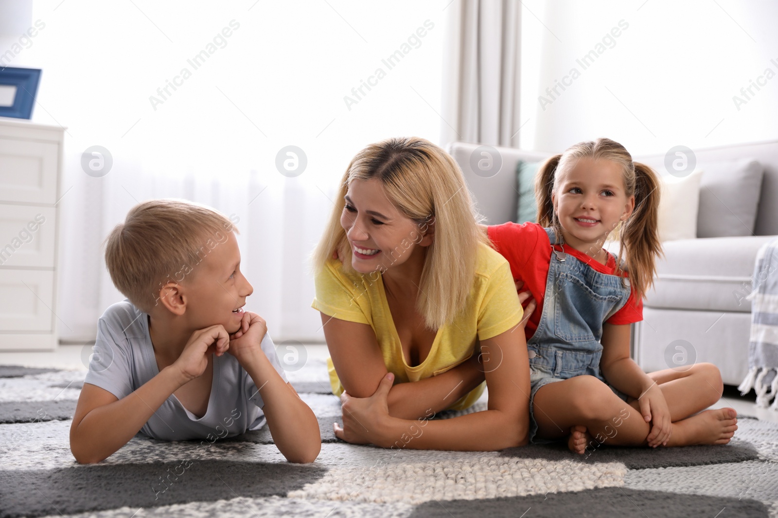Photo of Happy mother with her children on floor at home