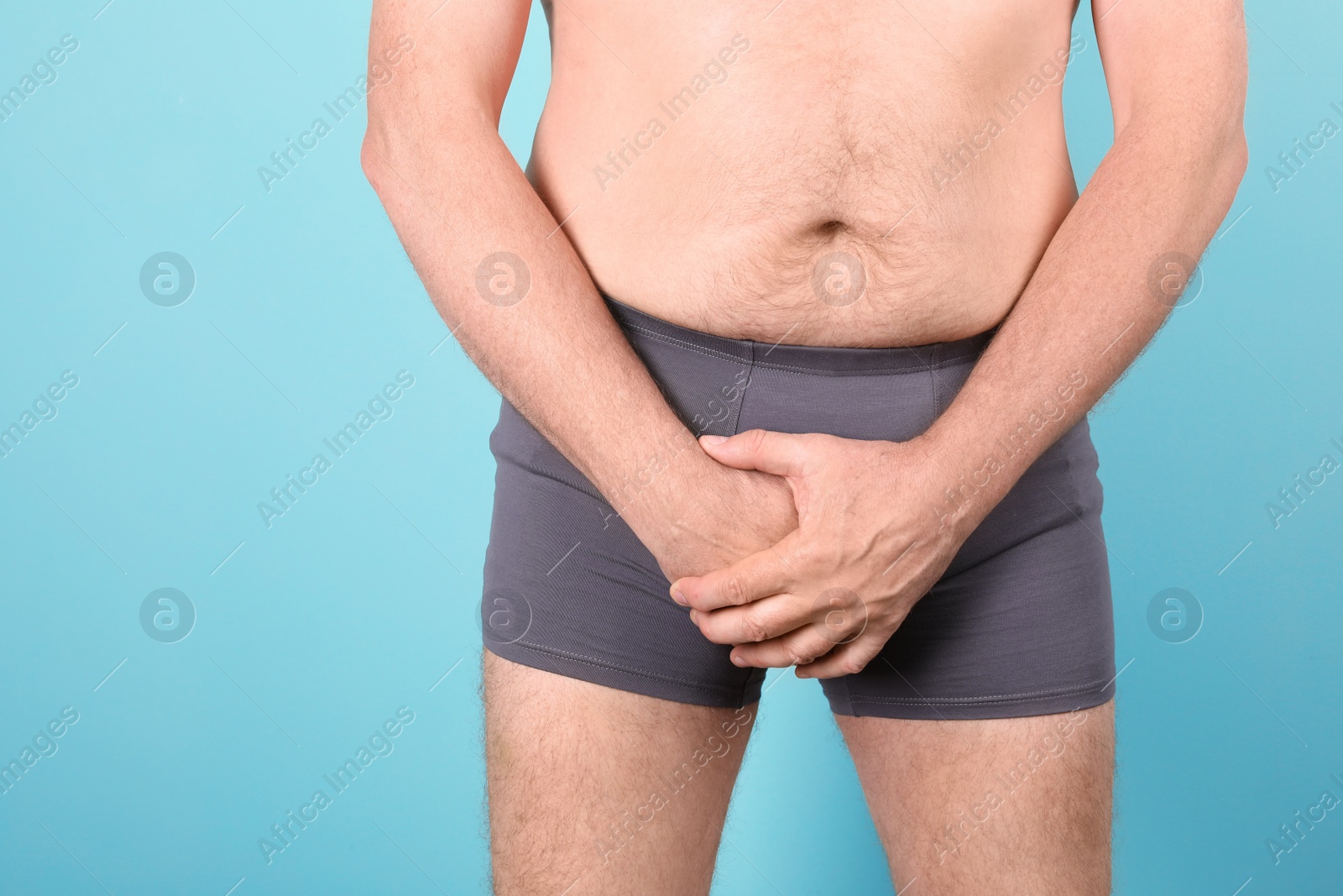 Photo of Mature man with urological problems suffering from pain on color background