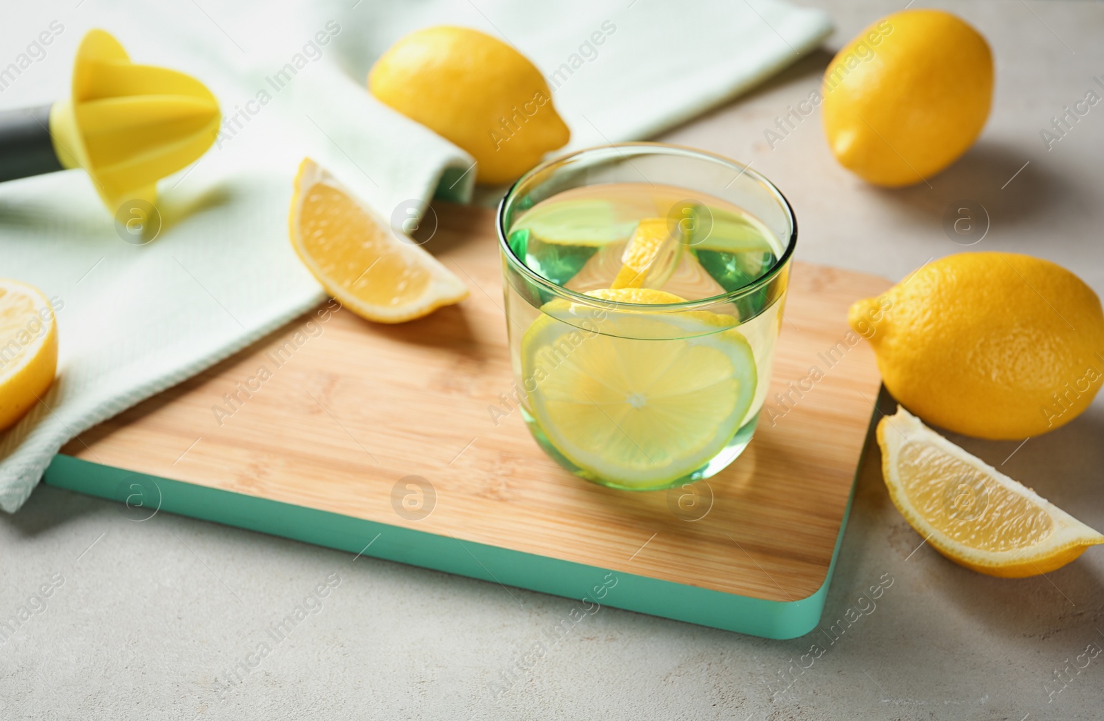 Photo of Glass of water with lemon slice on wooden board