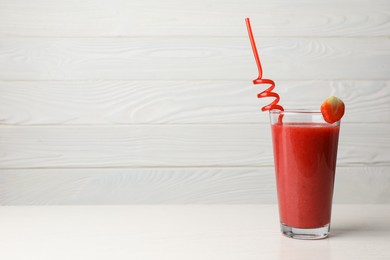 Photo of Glass with delicious strawberry smoothie on white wooden table. Space for text