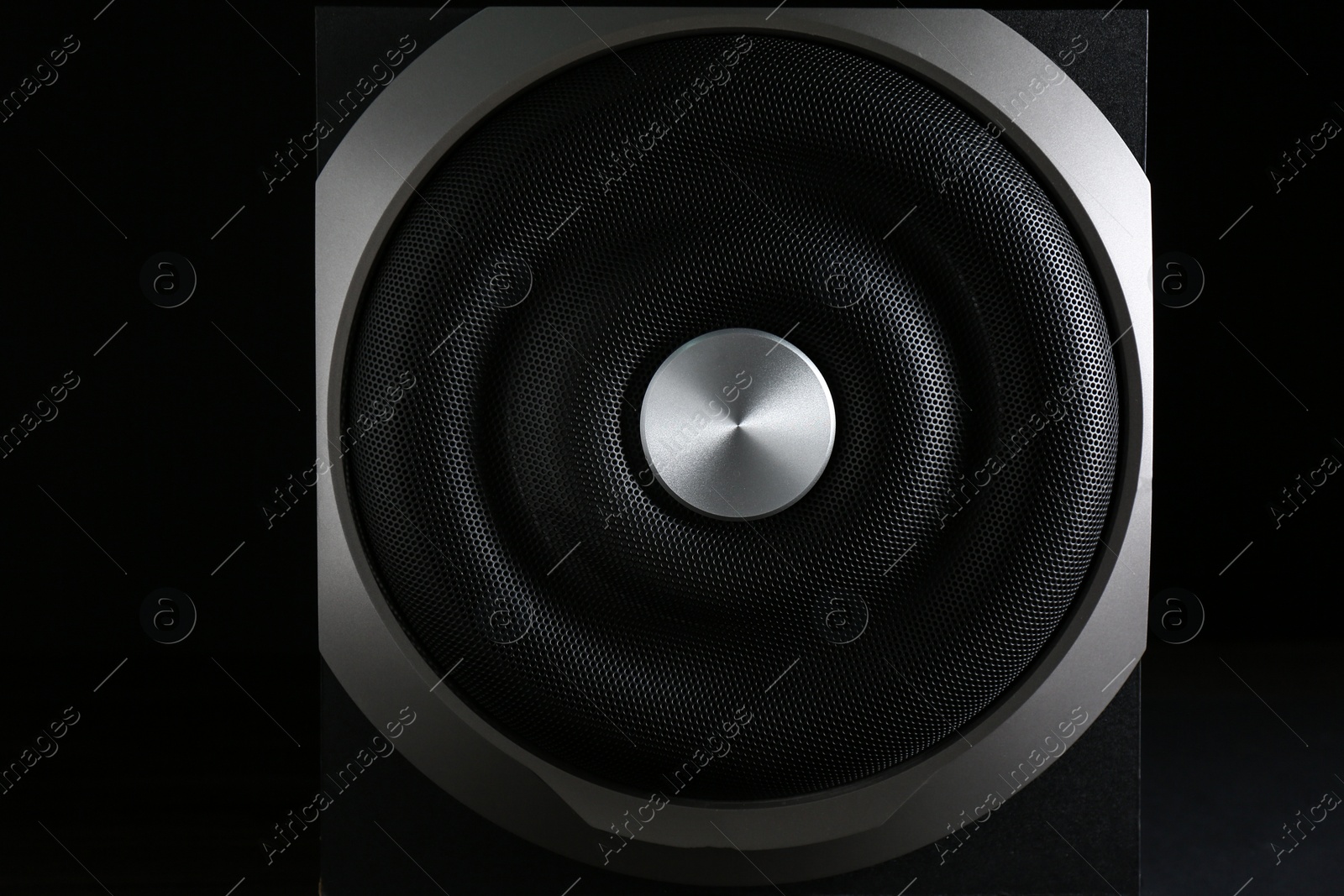 Photo of Modern subwoofer on black background, closeup. Powerful audio speaker