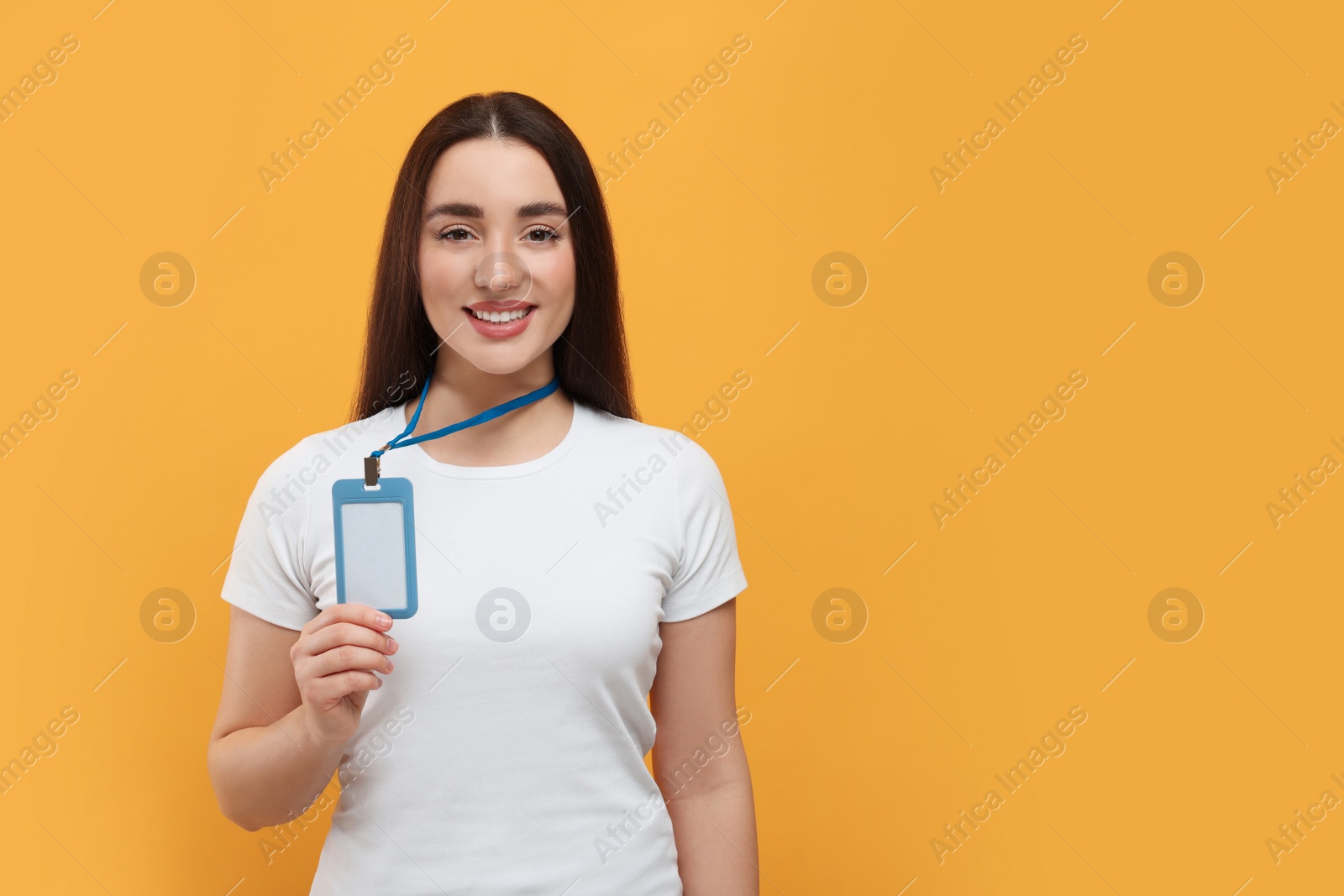 Photo of Happy woman with vip pass badge on orange background. Space for text