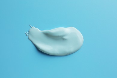 Sample of face mask on light blue background, top view