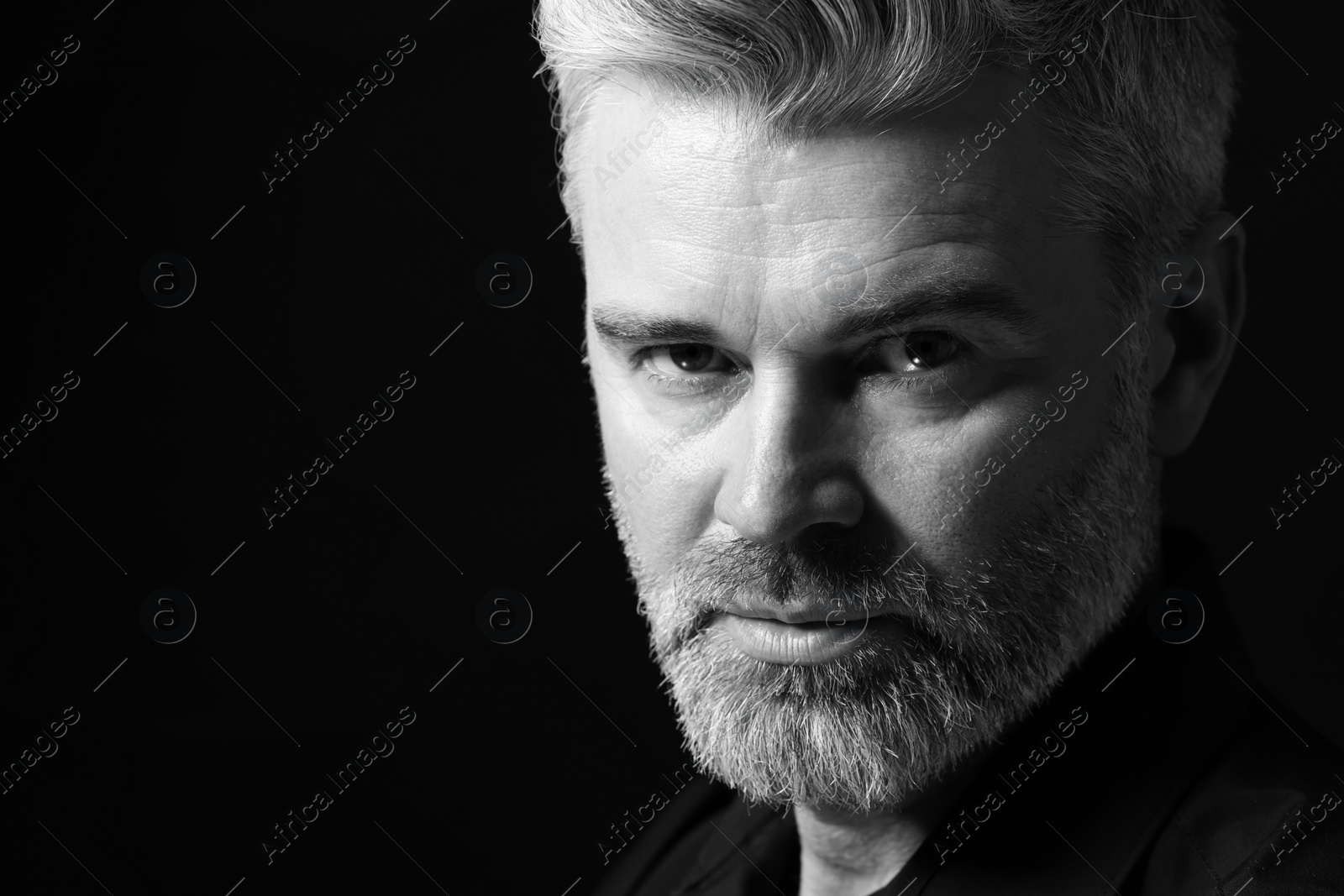 Photo of Portrait of handsome man on dark background, space for text. Black and white effect