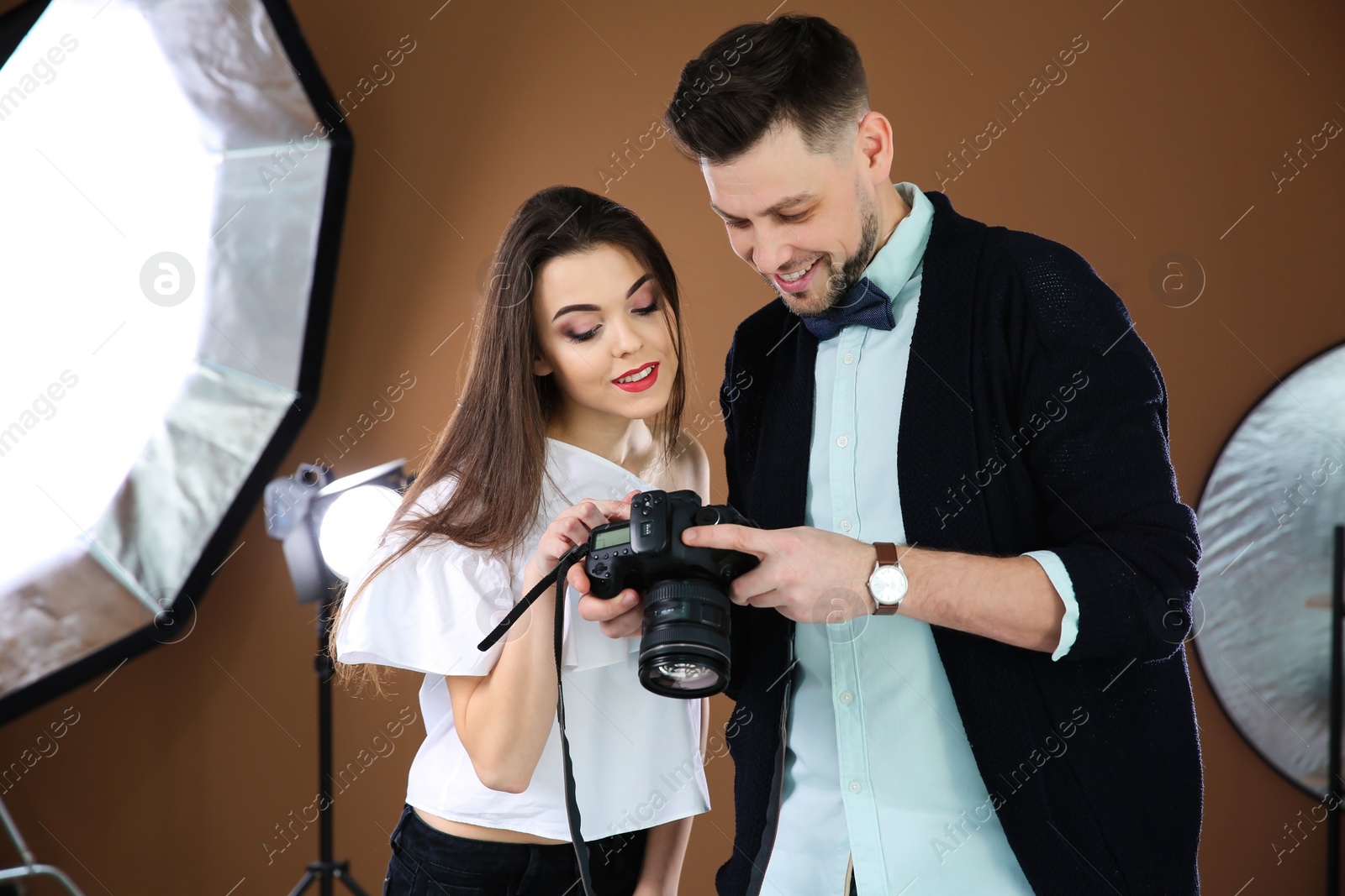 Photo of Beautiful young model with professional photographer in studio