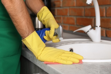 Photo of Man cleaning kitchen sink with rag, closeup