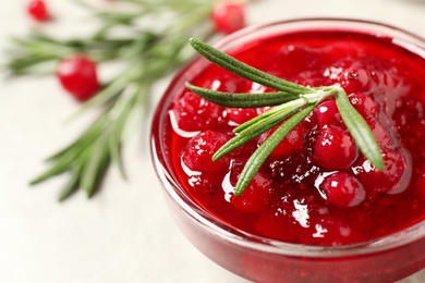 Photo of Cranberry sauce with rosemary in bowl, closeup. Space for text