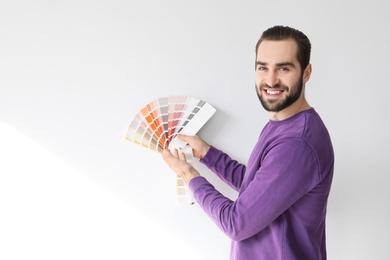 Photo of Young man with color palette on white background