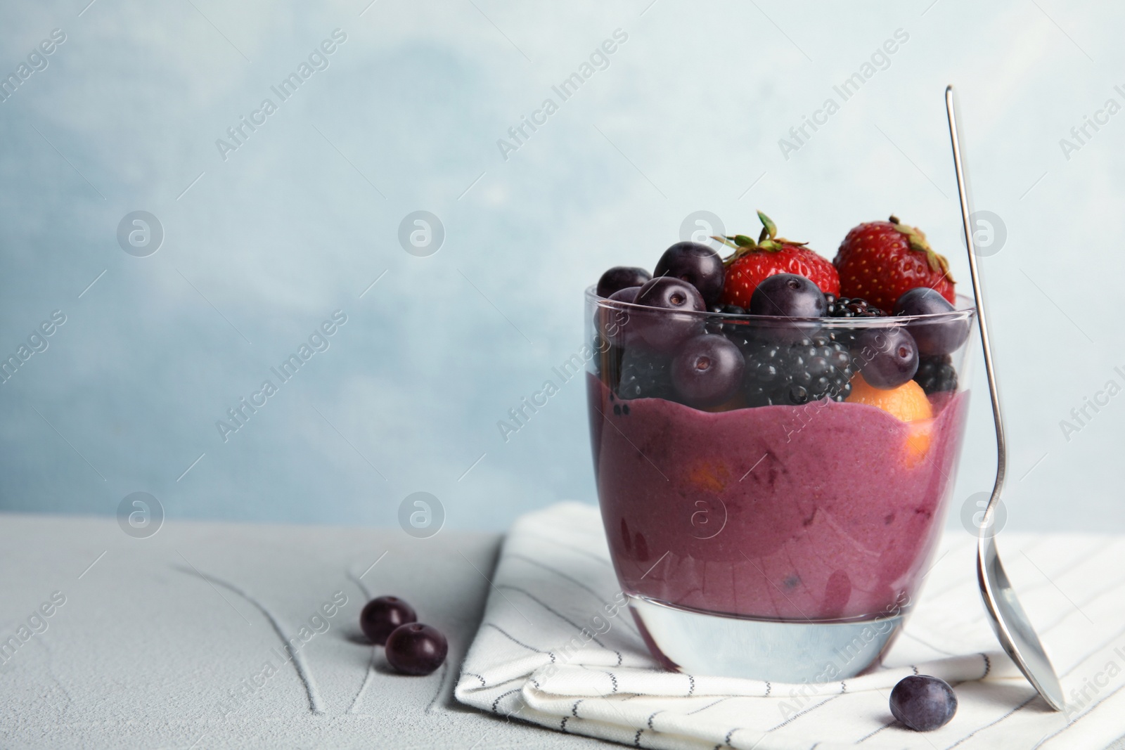 Photo of Glass with tasty acai smoothie on gray table