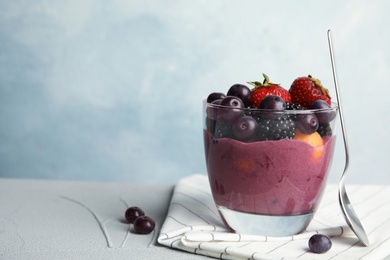 Glass with tasty acai smoothie on gray table