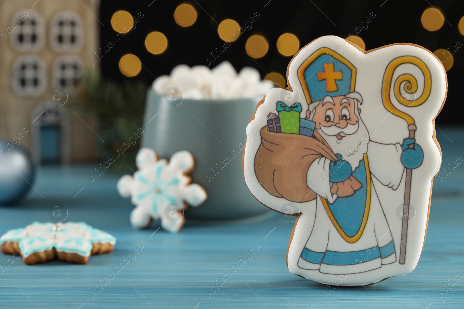 Photo of Delicious gingerbread cookies on blue wooden table, closeup. St. Nicholas Day celebration