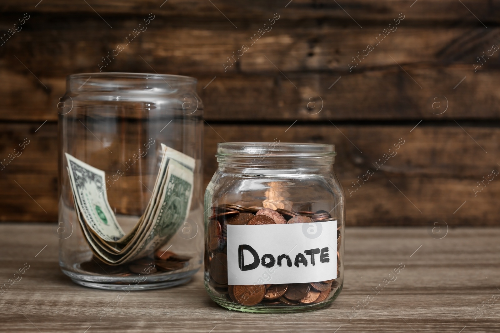 Photo of Donation jars with money on wooden table