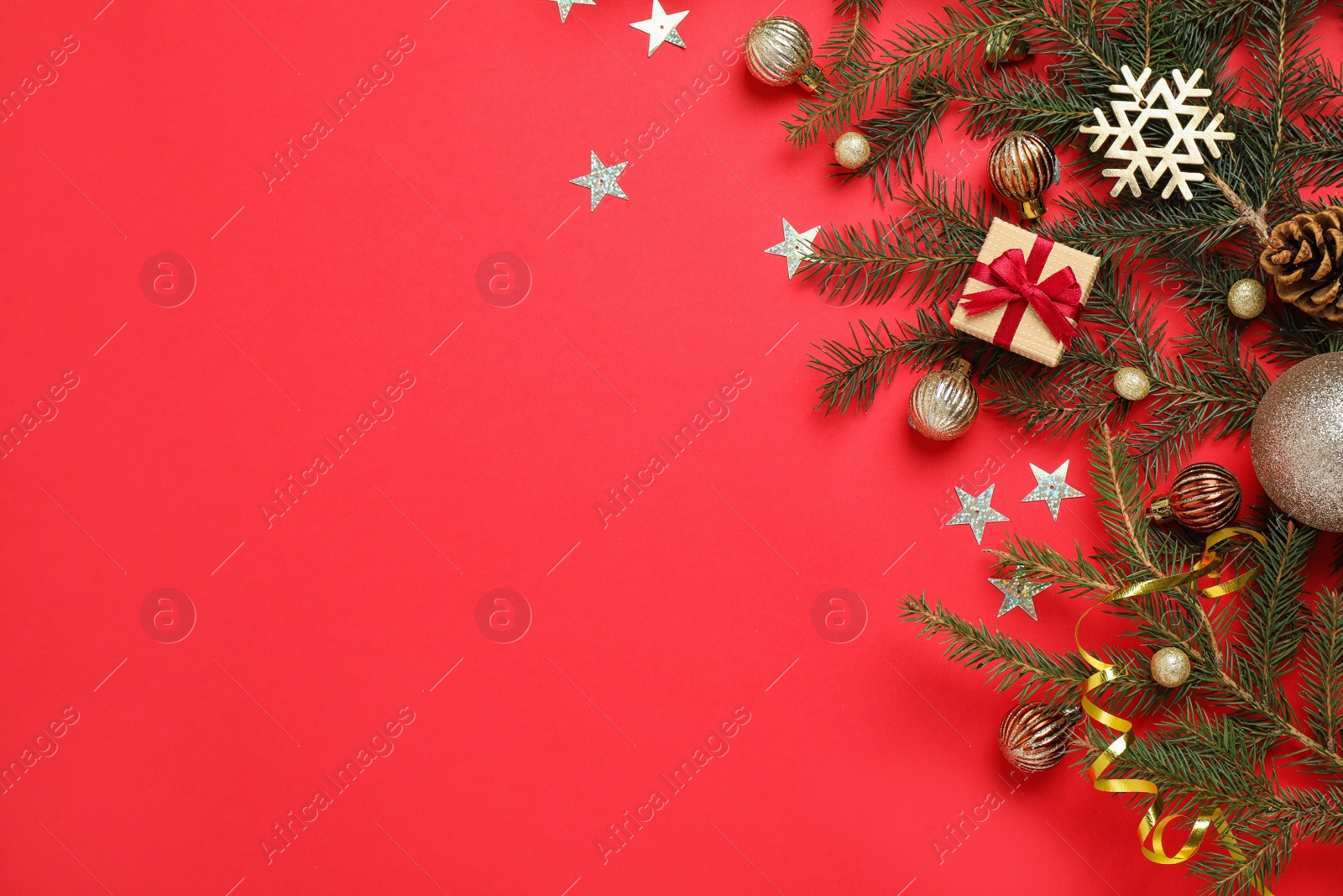 Photo of Fir branches with Christmas decoration on red background, flat lay. Space for text