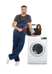 Plumber with wrench near washing machine on white background