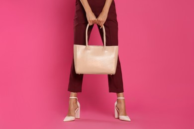 Photo of Woman with stylish bag on pink background, closeup