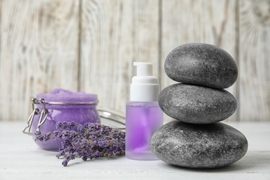 Composition with lavender flowers, spa stones and natural cosmetic on table
