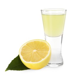 Shot glass with tasty limoncello liqueur, half of lemon and green leaf isolated on white