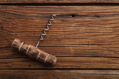 Photo of One corkscrew on wooden table, top view. Space for text