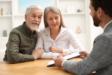 Photo of Notary consulting senior couple about Last Will and Testament in office