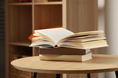 Photo of Stack of different books on wooden table indoors, space for text