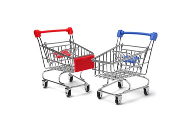 Empty mini metal shopping carts on white background