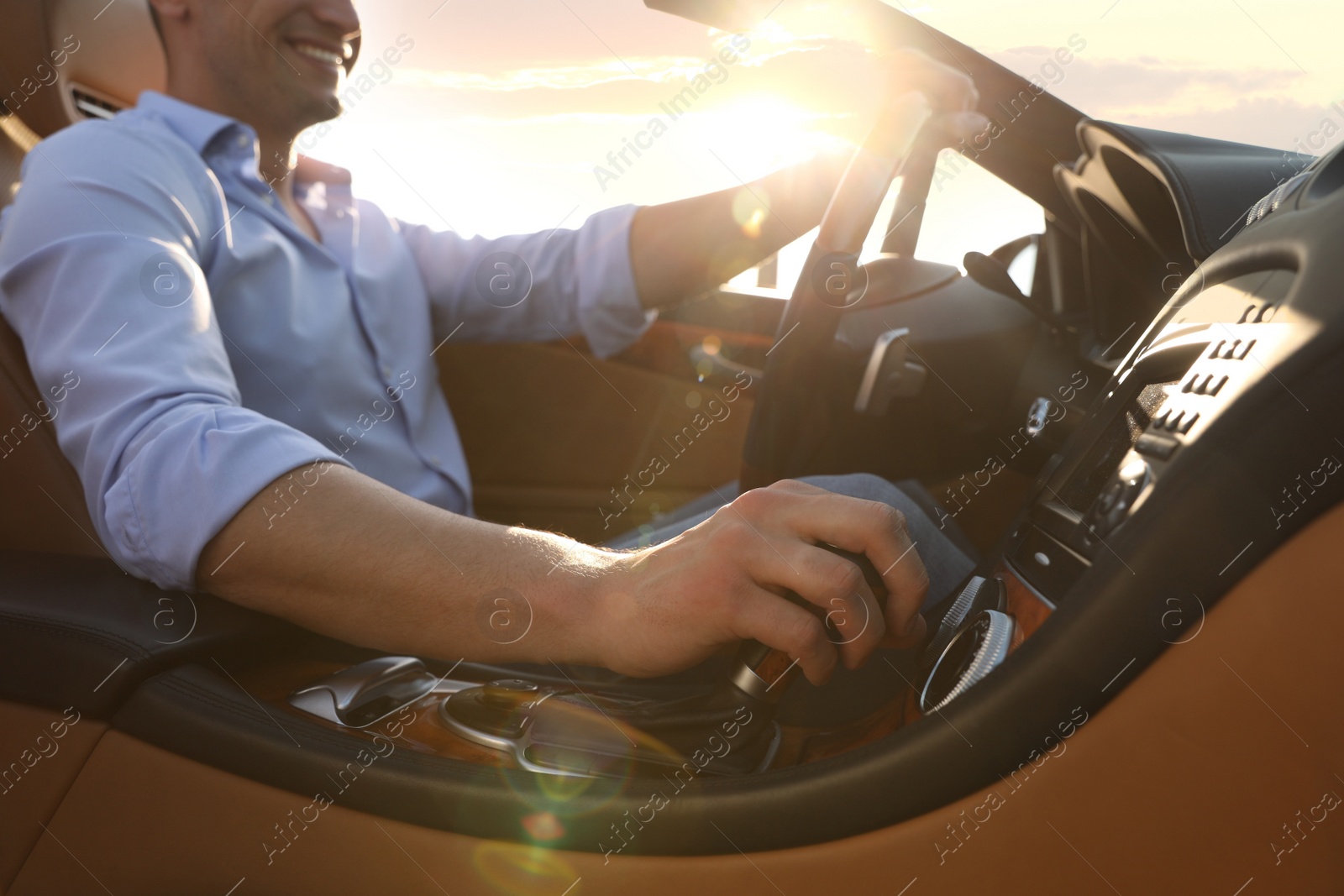 Photo of Businessman driving luxury convertible car outdoors, closeup