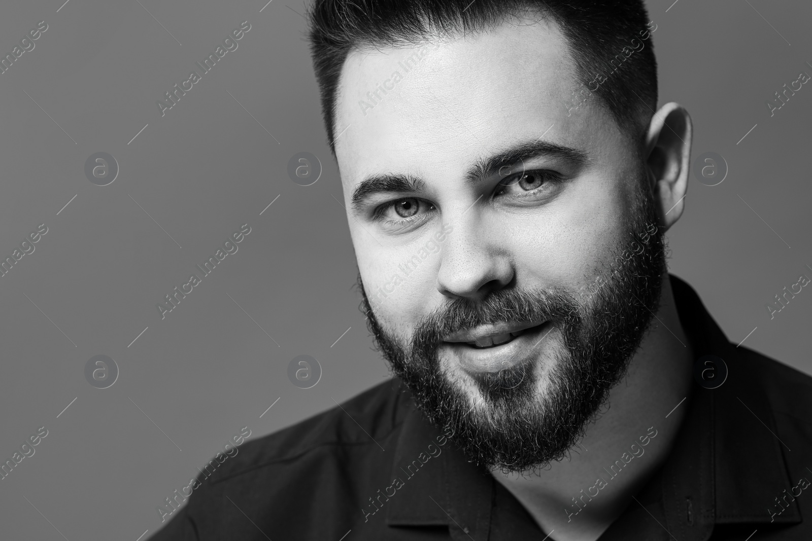 Photo of Portrait of handsome bearded man on grey background. Black and white effect