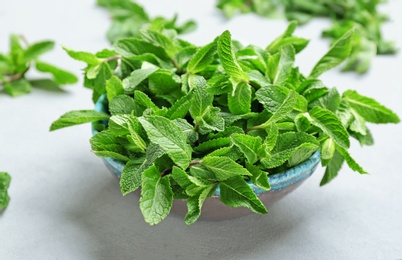 Photo of Bowl with fresh aromatic mint on table