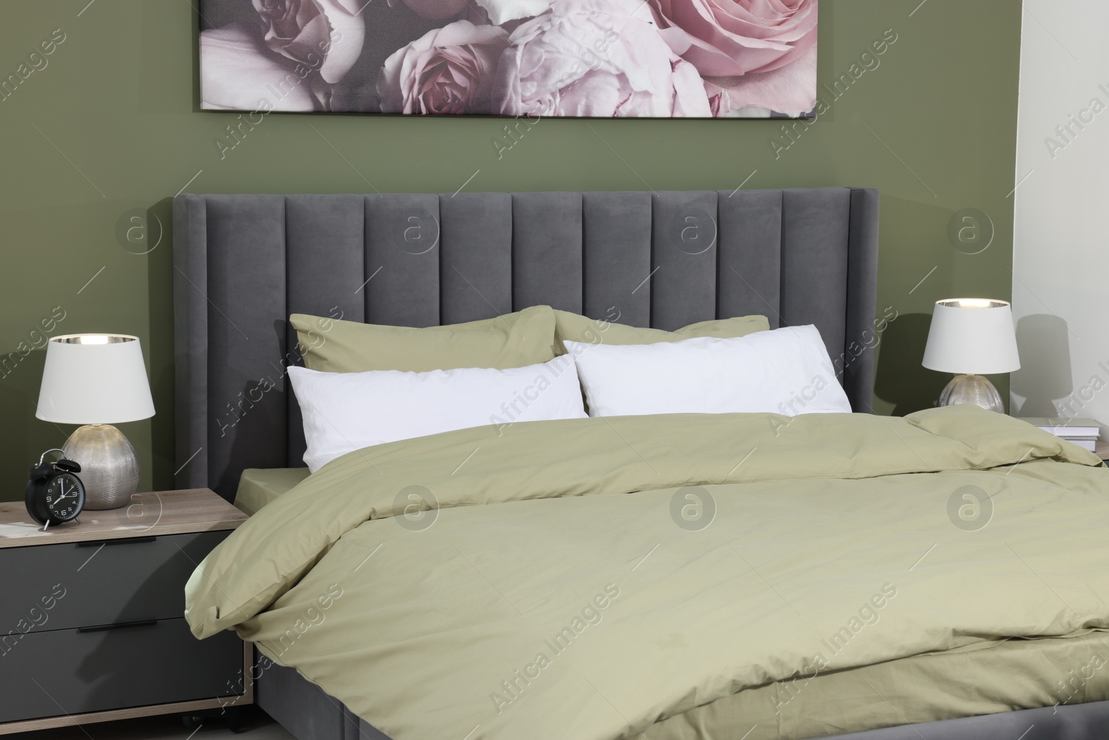 Photo of Comfortable bed and bedside tables with lamps in bedroom. Stylish interior design