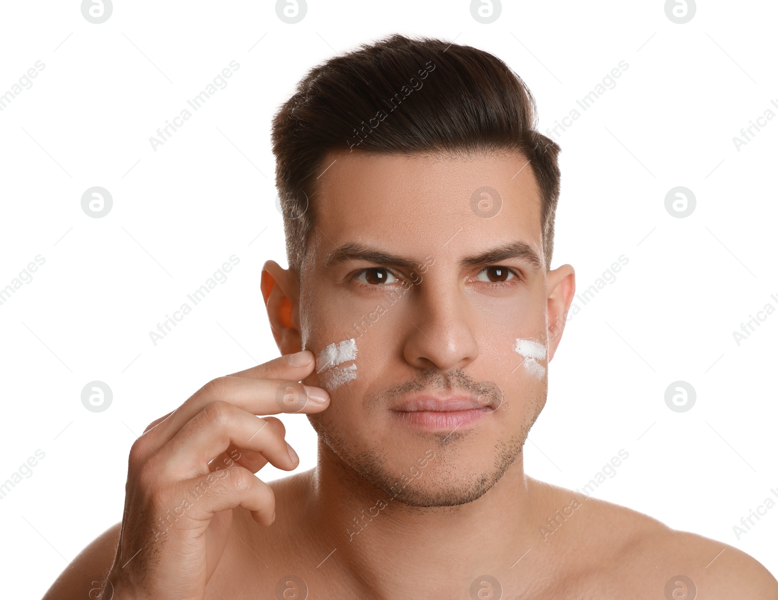 Photo of Handsome man applying face cream on white background