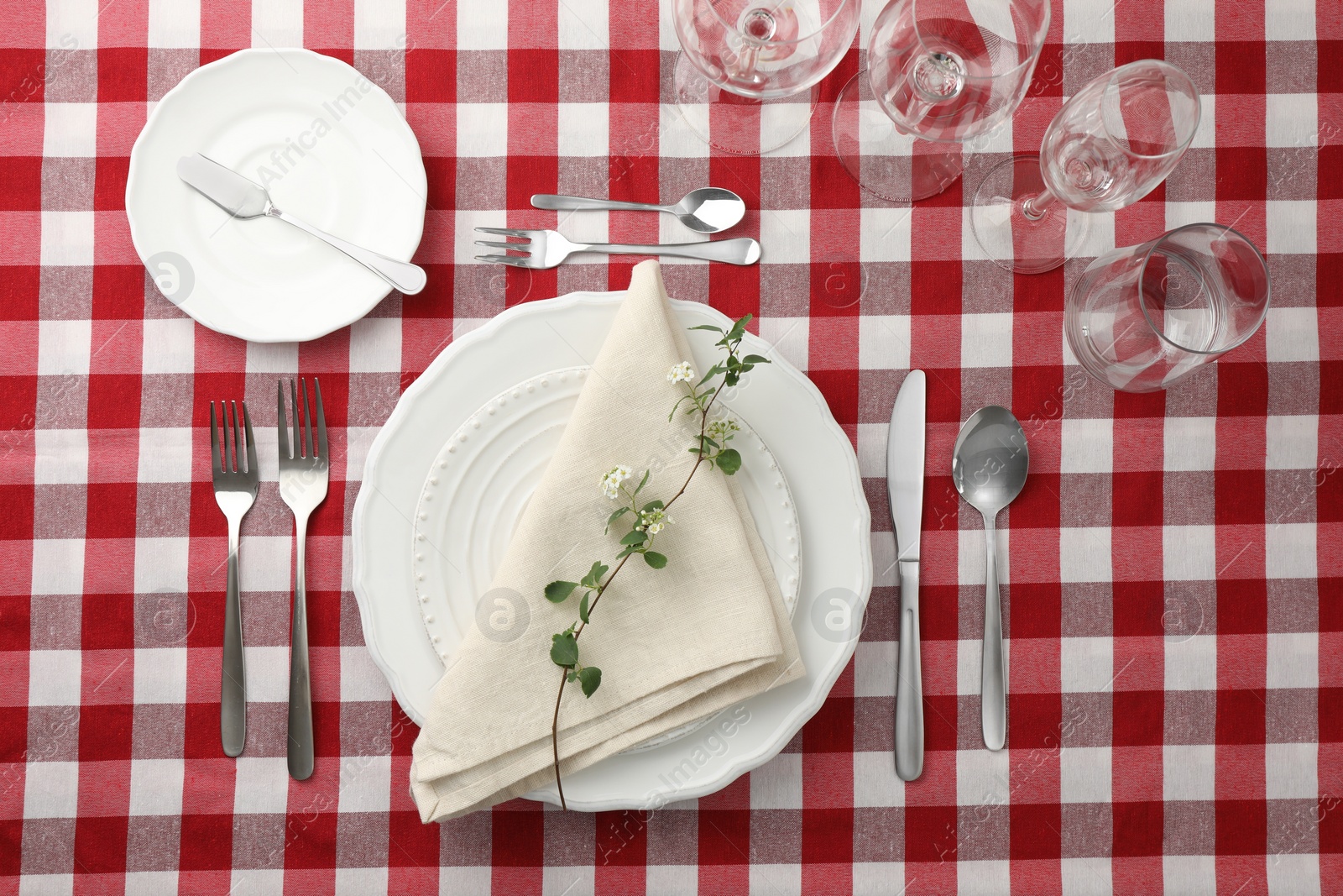 Photo of Stylish setting with cutlery, plates, napkin, glasses and floral decor on table, flat lay