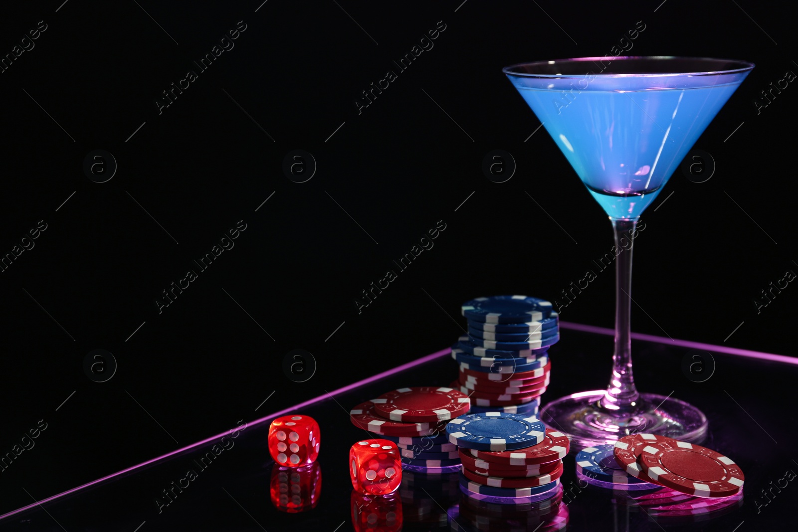 Photo of Casino chips, dice and cocktail on dark background, space for text