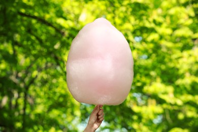 Woman holding sweet cotton candy outdoors, closeup