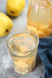 Delicious quince drink and fresh fruits on grey table, closeup