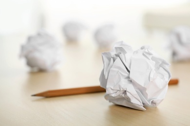 Photo of Sheet of crumpled paper and pencil on wooden table, space for text