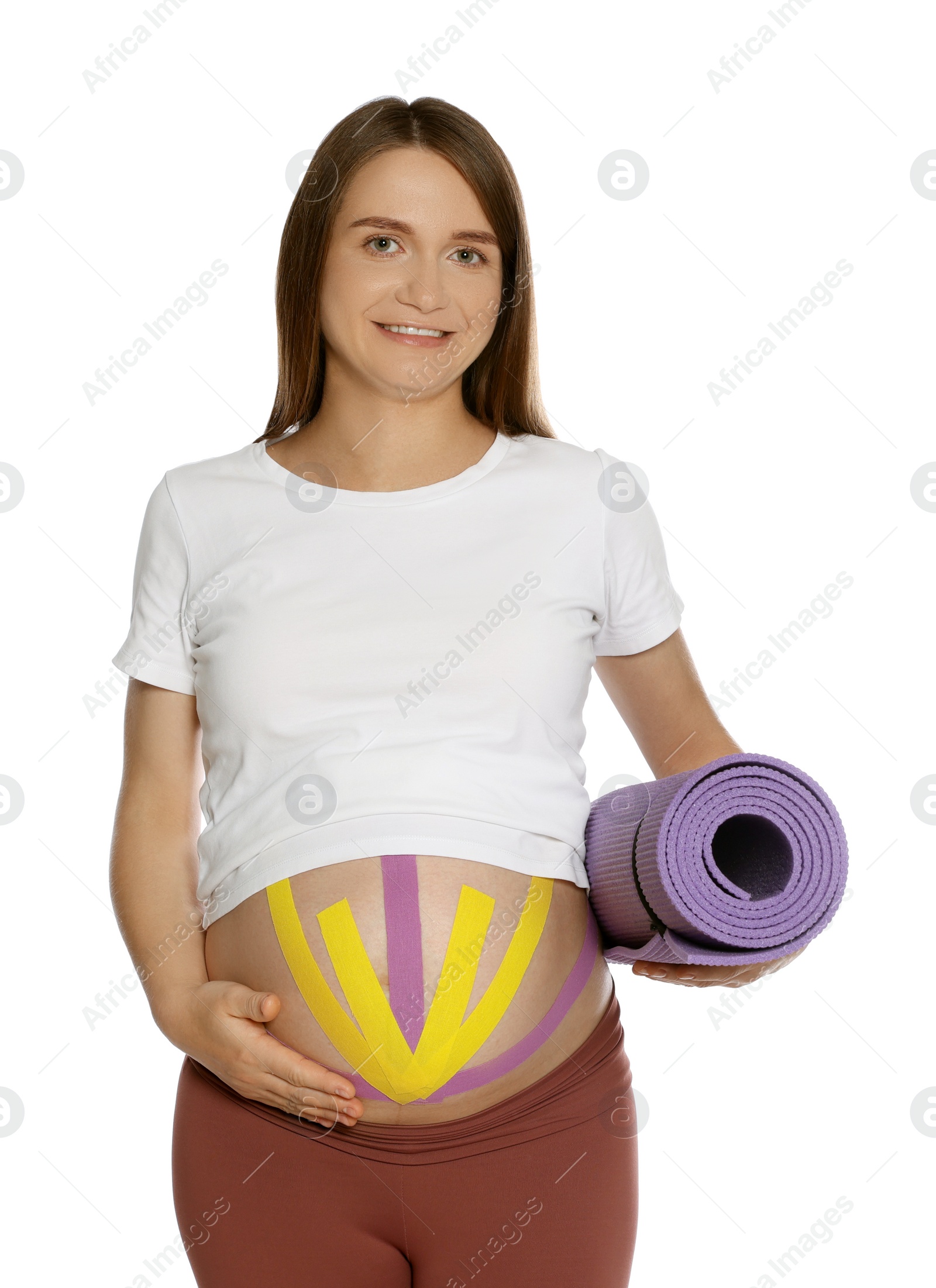 Photo of Sporty pregnant woman with kinesio tapes holding yoga mat on white background