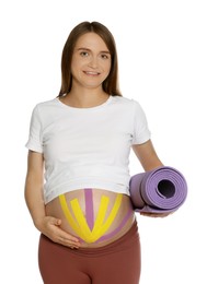 Photo of Sporty pregnant woman with kinesio tapes holding yoga mat on white background