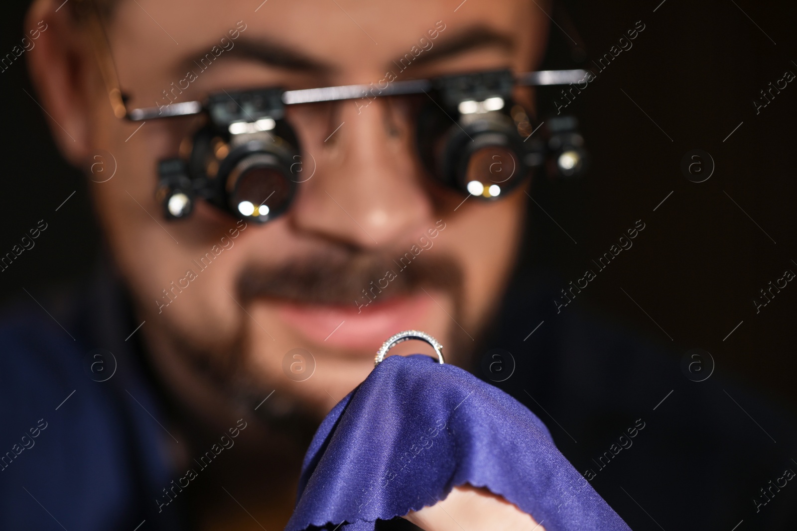 Photo of Jeweler working with ring on blurred background, closeup