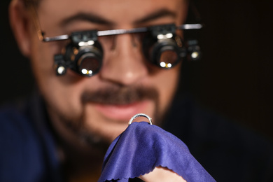 Jeweler working with ring on blurred background, closeup